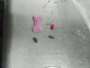 用模具压出紫色的蝴蝶结，椭圆形模具压出两个黑色的眼睛和红色的鼻子