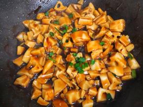 使藕丁均匀裹上糖醋汁撒葱花出锅啦！