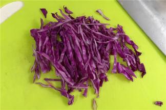 紫甘蓝用清水冲洗干净且沥干水分，用刀切丝。
