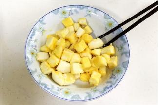 把鸡蛋液倒入馒头块中，用筷子拌匀，让馒头粒均匀裹上鸡蛋液。