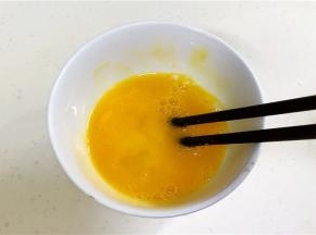 用筷子把鸡蛋打散开来。