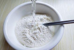 面粉放在容器中，酵母粉用温水融化，分次加入面粉中，用筷子搅成絮状。再揉成面团，进行发酵，发酵至原来的两倍大。