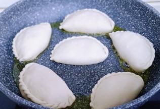 不粘锅中加入适量油，将包好的韭菜盒子放入锅中并间隔距离。