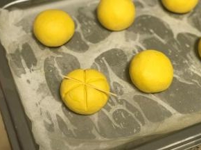 用牙签在面团上压出南瓜条纹，正中间再插上葡萄干，依次完成所有。