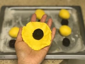 将南瓜面团擀成圆形面皮，放入一粒豆沙馅儿。