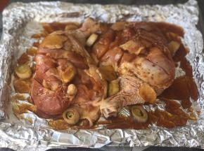 腌好的鸡腿皮朝下放在铺了锡纸的烤盘上，将料汁调料一并倒入，倒的时候均匀淋在鸡腿上。