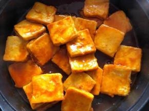 把调好的糖醋酱汁淋入豆腐上，使每块豆腐都均匀裹上酱汁