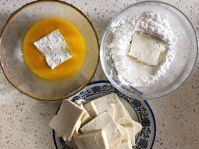 豆腐切均等的厚度，豆腐分别先蘸生粉然后蛋液；待锅中油烧热