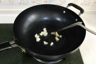 开火，热锅冷油，待食用油7成热时，把蒜和姜片放入锅中爆香。