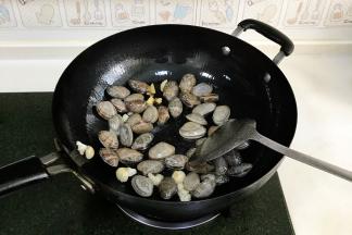倒入沥干水分的花蛤翻炒片刻。