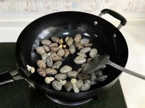倒入沥干水分的花蛤翻炒片刻。