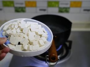 锅仔里加水煮开，将豆腐切丁下锅煮至浮起。