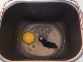 将清水，玉米油和鸡蛋放入面包机桶内。