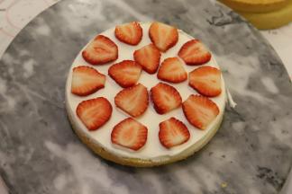 取一片蛋糕片，抹好淡奶油，放上切成片的草莓片，再抹好淡奶油。