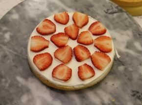 取一片蛋糕片，抹好淡奶油，放上切成片的草莓片，再抹好淡奶油。