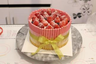 上面放上洗净擦干的草莓，洒上少许防潮糖粉，打上蝴蝶结。