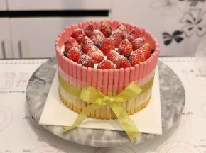 上面放上洗净擦干的草莓，洒上少许防潮糖粉，打上蝴蝶结。