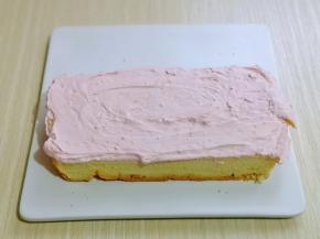 制作将汽车体部分，取一片蛋糕抹上打发的奶油。