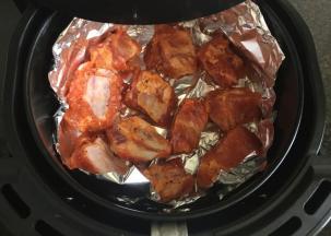 炸蓝内放一张锡箔纸，放入腌制好的排骨，放进空气炸锅中200度烤12分钟；