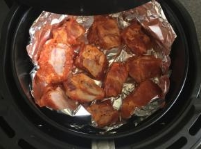 炸蓝内放一张锡箔纸，放入腌制好的排骨，放进空气炸锅中200度烤12分钟；