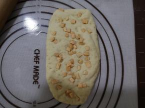 12、将面剂旋转90度，擀开后再撒上红薯丁，稍擀一下。