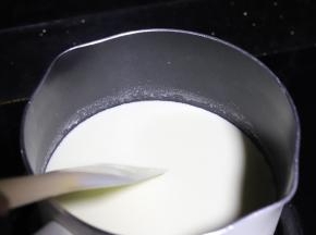 牛奶、淡奶油和细砂糖倒入奶锅，小火加热至边缘冒小泡泡后关火。