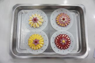 同样的方法做出不同颜色的小花，放入蒸盘，放温暖处进行发酵，因为是一次发酵，时间稍微长一些，夏天发酵室温即可，冬天的话可以借助烤箱（需要放一碗热水，保持湿度）或蒸箱，利用发酵功能，发至于1.5倍大，用手指轻按表面可缓慢回弹即可。发酵的时间与温度、整形的时间有关，注意观察馒头的状态。