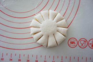 用刮面板沿着周边均匀的切出刀口，刀口长度不要太长，切到面饼的3/5处即可，中央处保留不要切断，形成花瓣状。