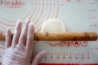 收口向下，按扁，用擀面杖擀成圆饼。