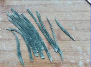 将用深可可粉调出来的黑色面团，用擀面杖擀成薄片，然后切出小细条，做为枝干部分。