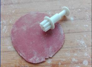 将用红曲粉调出来的面团，同样擀成薄片。