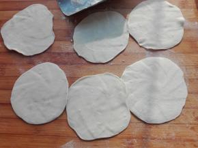 将其切好的剂子，用擀面杖擀成周边薄，中间厚的面皮，如图所示。