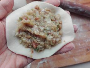 在擀好的包子里上，放入适量的馅料，如图所示。