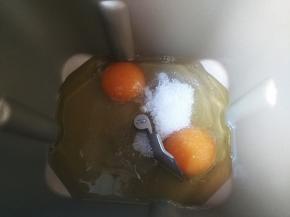 将鸡蛋、白糖、花生油和酵母放入面包桶，启动面包机，搅拌均匀