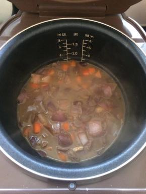 将煮好的牛肉和汤汁一起倒入电饭煲中