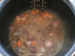 将煮好的牛肉和汤汁一起倒入电饭煲中