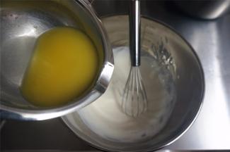 黄油隔热水加热融化后，慢慢倒入到奶酪糊中，边倒边搅拌均匀。