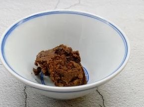 拿干黄酱放入碗里。