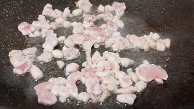 锅里加葱姜蒜爆香，加肉丁翻炒。