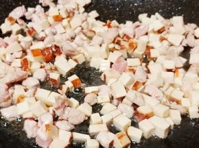 待肉丁翻炒变色加豆干翻炒片刻。