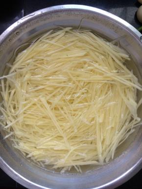 将切好的土豆丝放入盆中，加入适量水浸泡大概20分钟，去掉多余的淀粉。