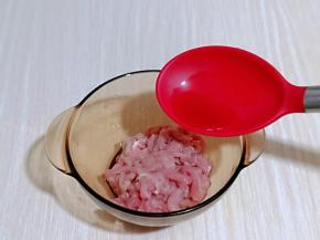 将切好的肉丝加入器具中，再加入料酒。
