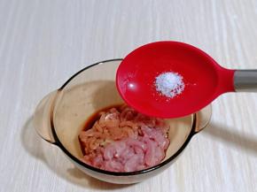 将肉丝放入器具中，加入盐。