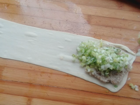 肉馅上面放入葱沫，撒上适量花椒粉