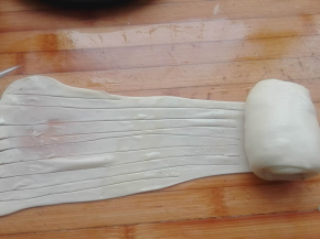 将其边抻拉边卷起来，还剩下一段时，用刀将其划上小细条