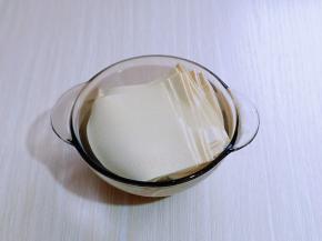 切好的干豆腐皮用开水烫2-3分钟，再捞出淋干水分。