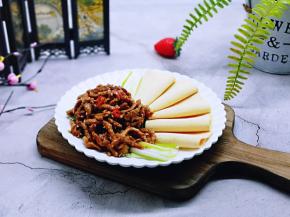 盛入摆放好的京葱和干豆腐皮盘中，撒上熟白芝麻。