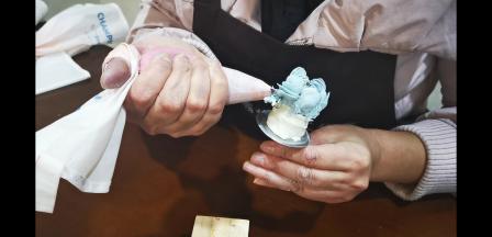 在两瓣之间，花嘴垂直插入，挤，左手转钉，右手向斜下方拉，做上5组