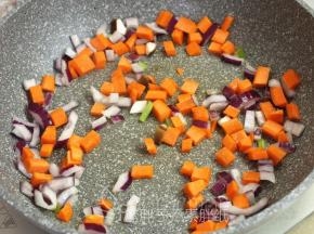 接着放入胡萝卜，稍微翻炒一下之后放入适量的水，将胡萝卜炒熟。