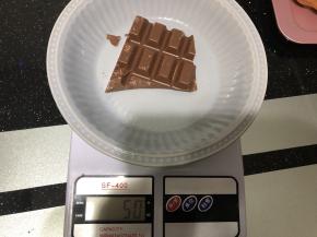 50g巧克力用温水融化之后，把甜甜圈一半沾上巧克力。